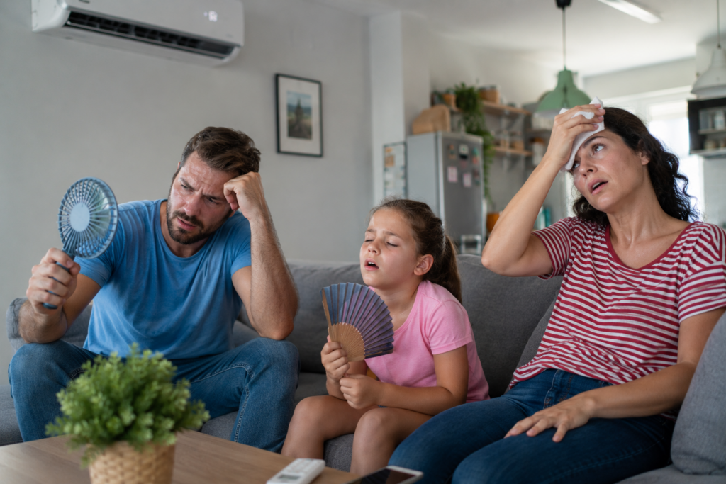 Hot and uncomfortable family with AC on. The AC is leaving the house due to poor insulation.